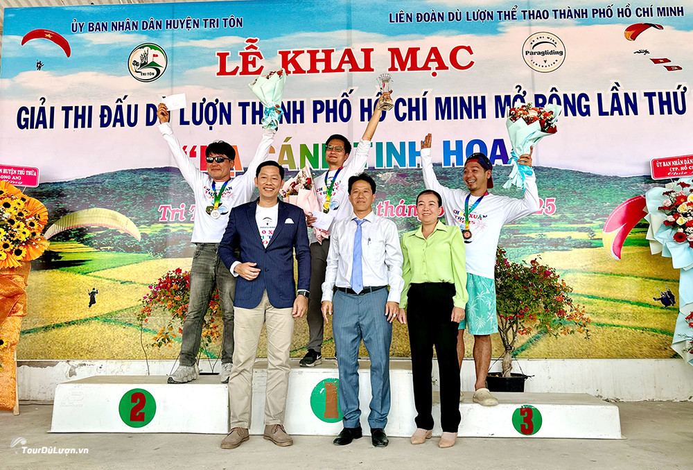 The three pilots who won the highest prizes at the Ho Chi Minh City Open Paragliding Tournament 2025, stood on the award podium in Tri Ton, An Giang. They received trophies, medals and flowers from the Organizing Committee at the award ceremony.